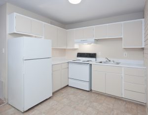 Drab old white cupboards in an open kitchen