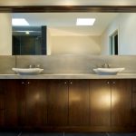 Custom bathroom cabinets in dark brown with stainless handles, made and installed by Evolve Kitchens of Calgary